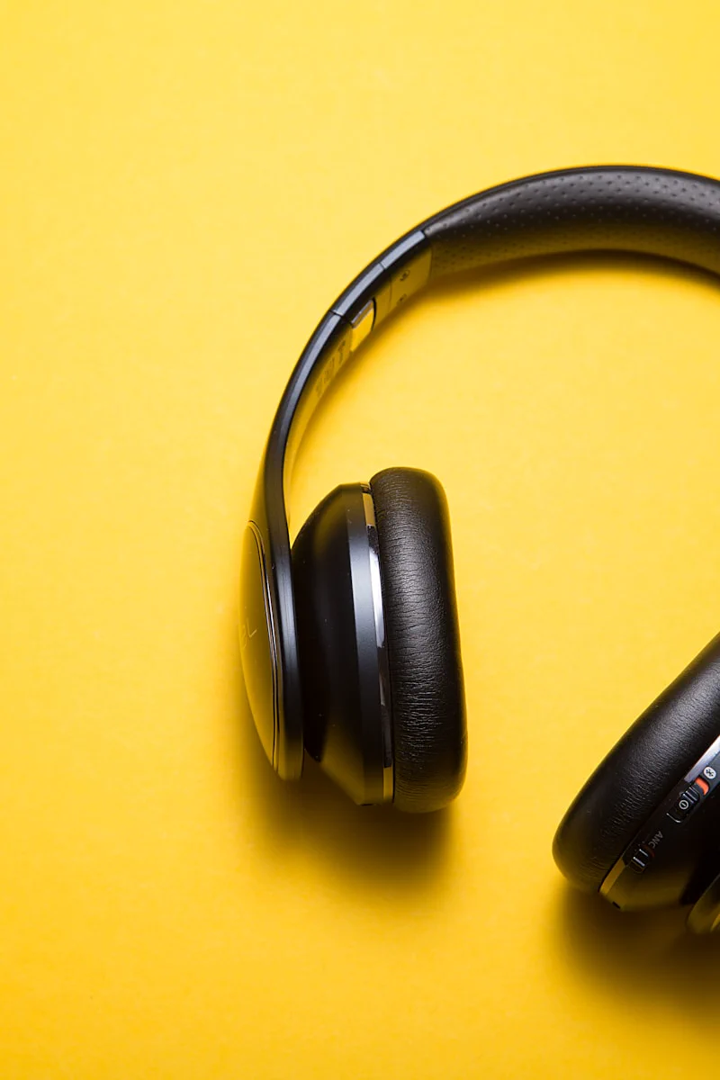 Black wireless headphones on yellow background showcasing audio accessibility features